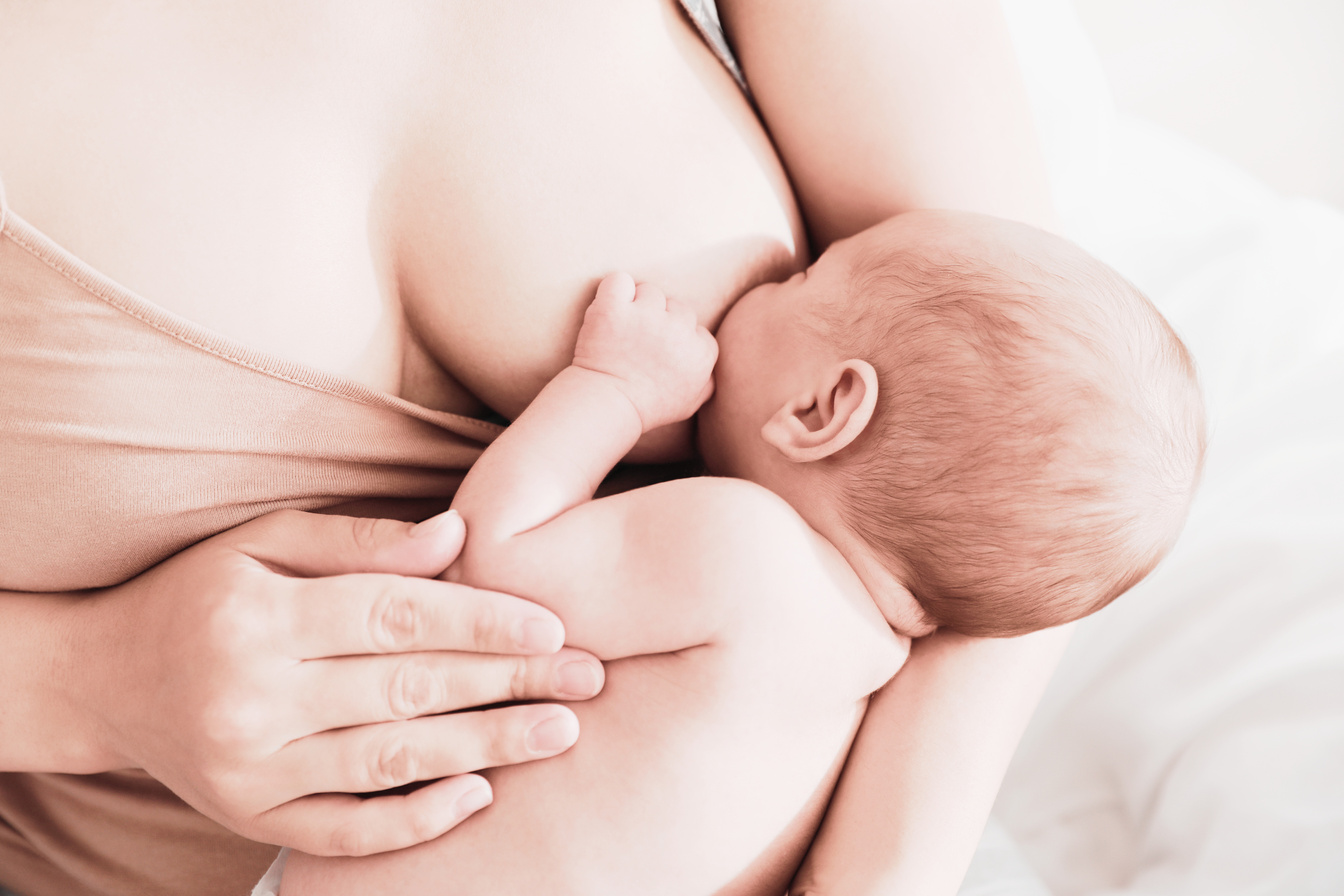 Mother Breastfeeding Her Newborn Baby at Home, Closeup